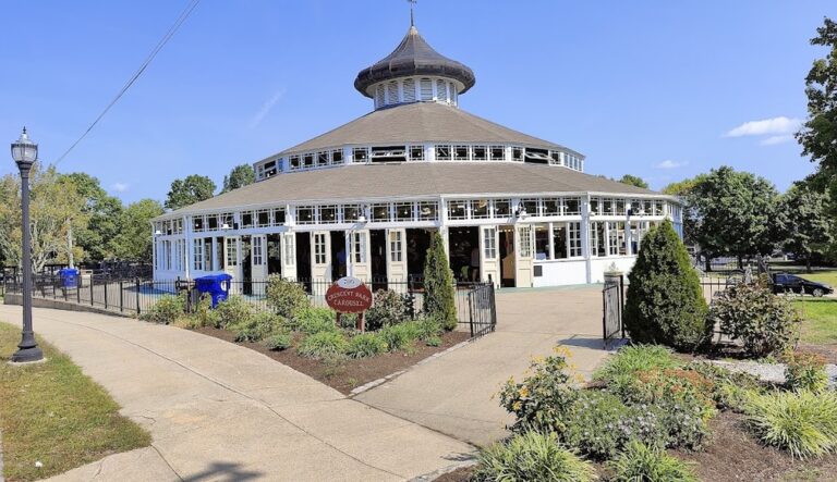 Colorful view of the historic Crescent Park Carousel in East Providence, RI, featuring intricately carved wooden horses and vintage details under a bright canopy.