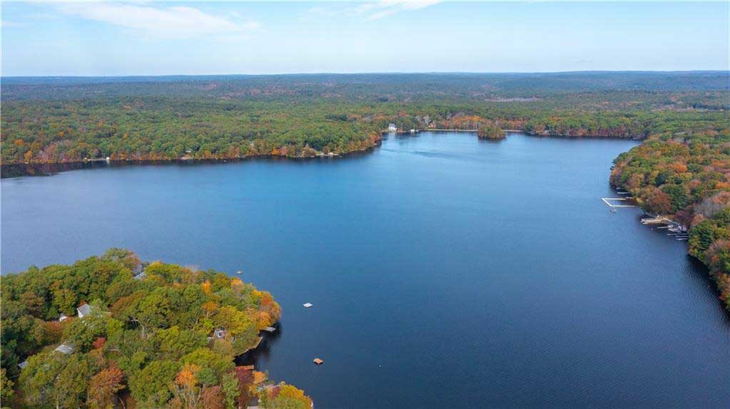 Flat River Reservoir in Coventry, RI, a calm body of water surrounded by trees, ideal for boating, fishing, and outdoor relaxation.