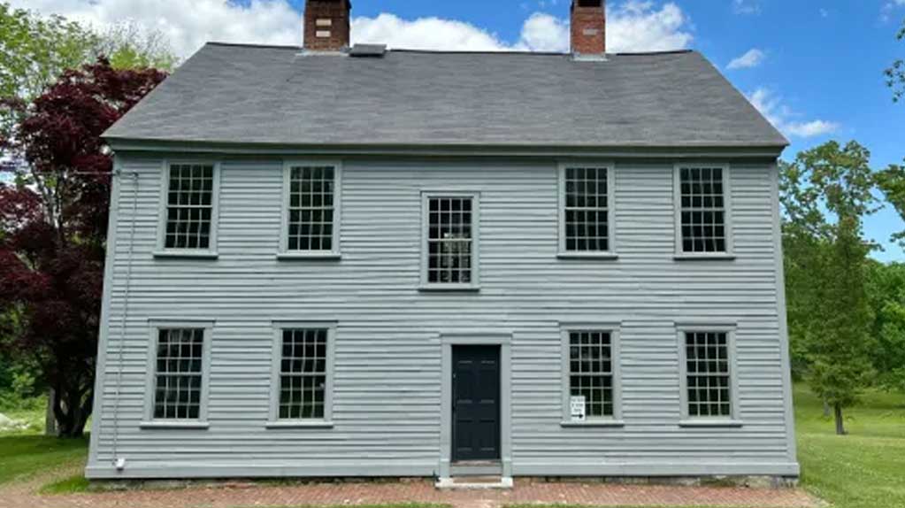 Nathanael Greene Homestead in Coventry, RI, a historic colonial house with large windows, surrounded by green lawns and trees.